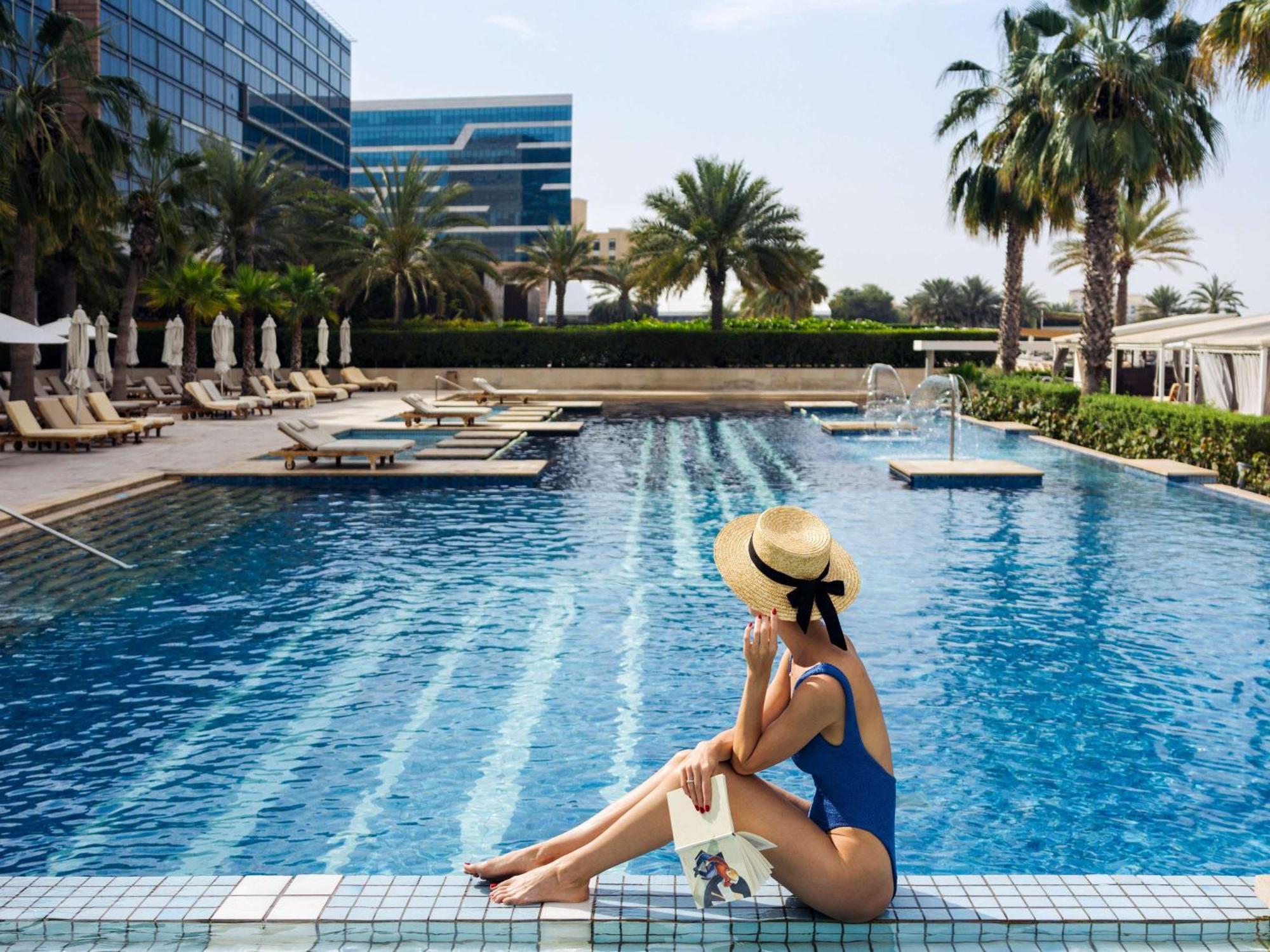 Fairmont Bab Al Bahr Hotell Abu Dhabi Eksteriør bilde A woman sunbathing at a pool